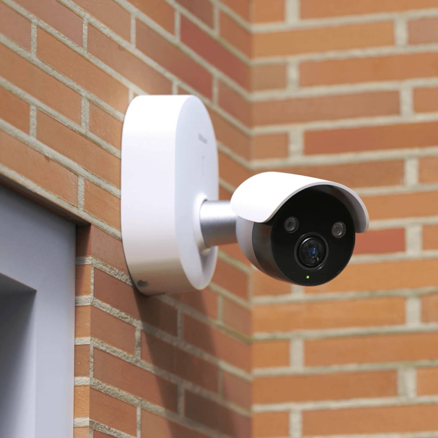 Ulticam IQ 2K UHD Smart Security Camera installed on brick wall – outdoor WiFi surveillance with AI detection and infrared night vision.