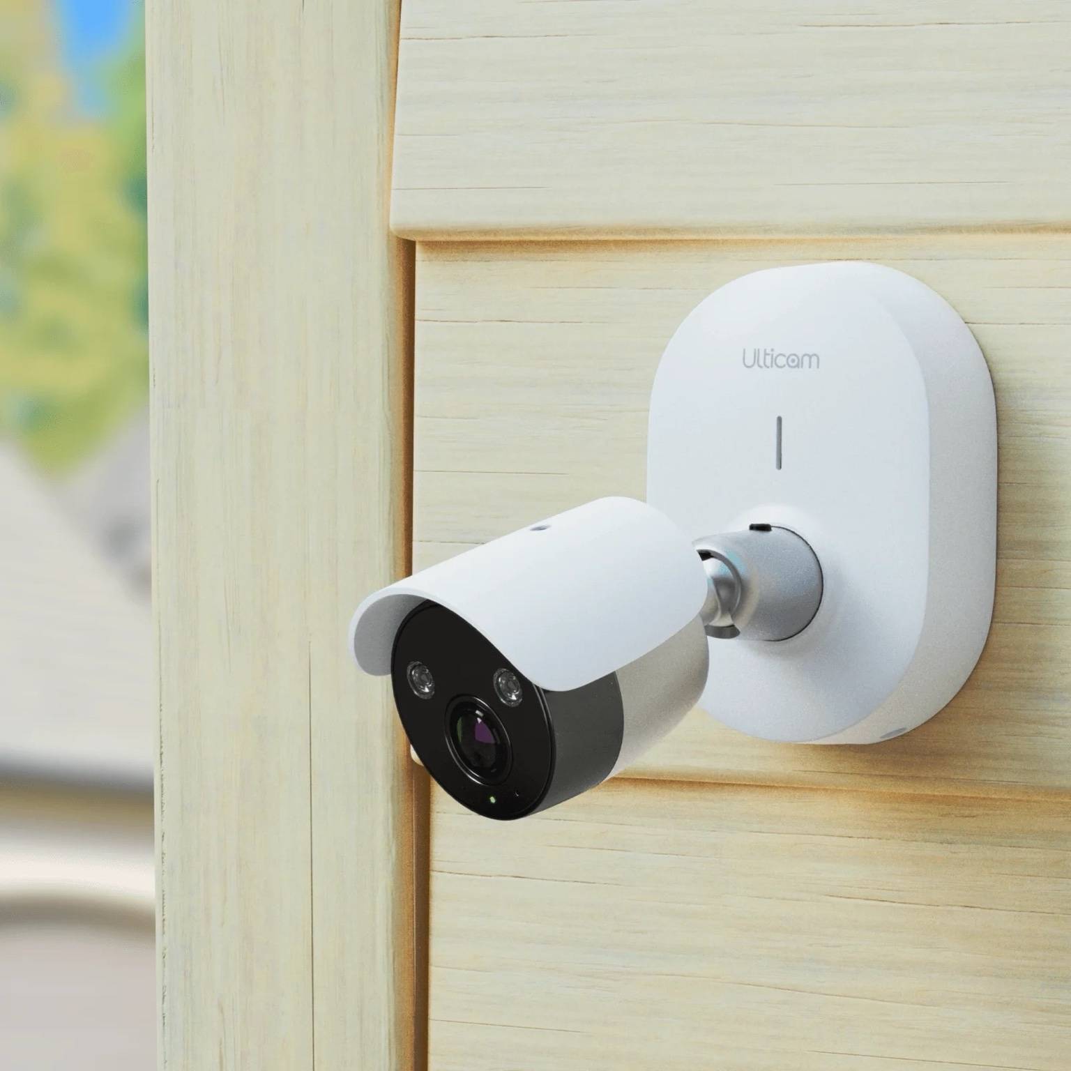 Ulticam IQ 2K UHD Smart Security Camera mounted on wooden siding – outdoor WiFi surveillance with AI motion detection and night vision.